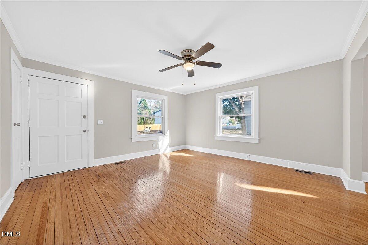23 West Academy Street Wendell, NC 27591 - Photo 7 of 31 a view of empty room with wooden floor and fan