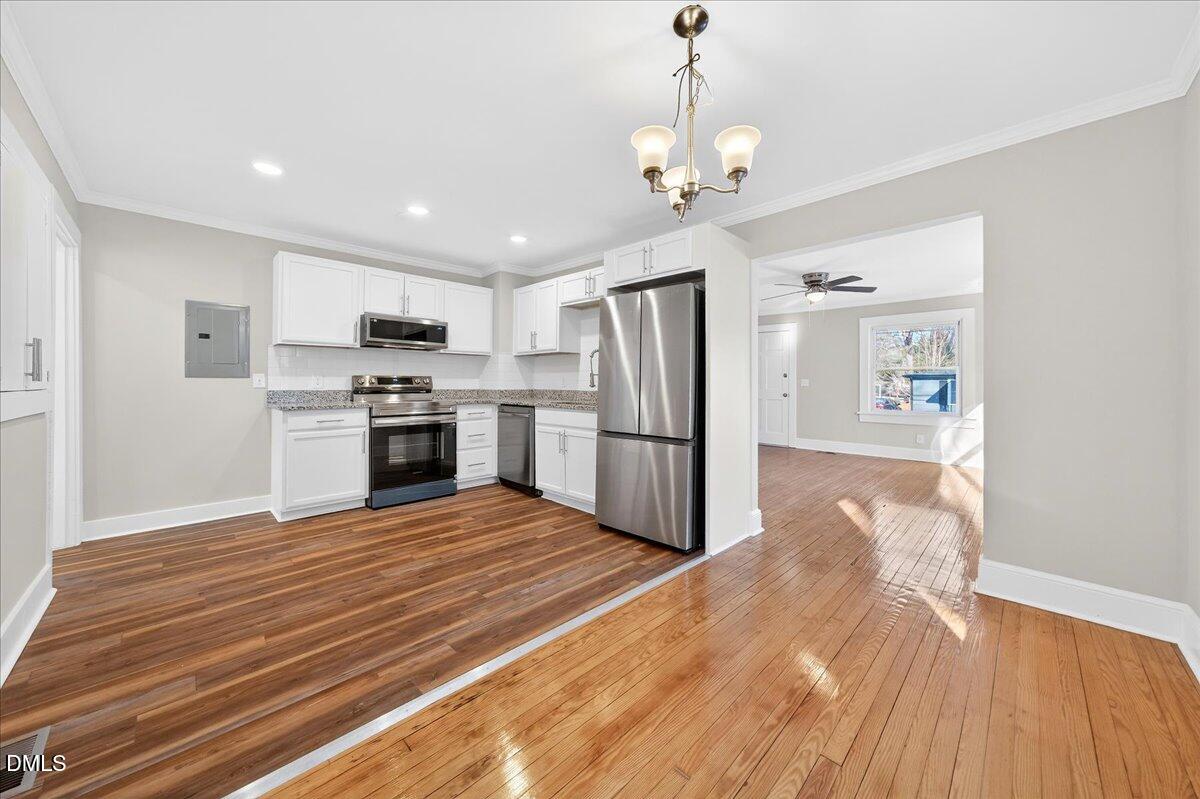 23 West Academy Street Wendell, NC 27591 - Photo 9 of 31 a large kitchen with kitchen island a stove a refrigerator cabinets and wooden floor