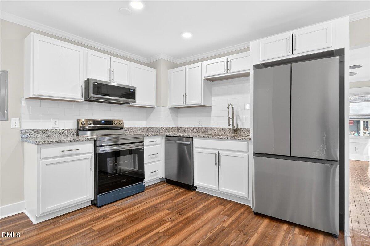 23 West Academy Street Wendell, NC 27591 - Photo 10 of 31 a kitchen with stainless steel appliances granite countertop a refrigerator stove a sink and a microwave
