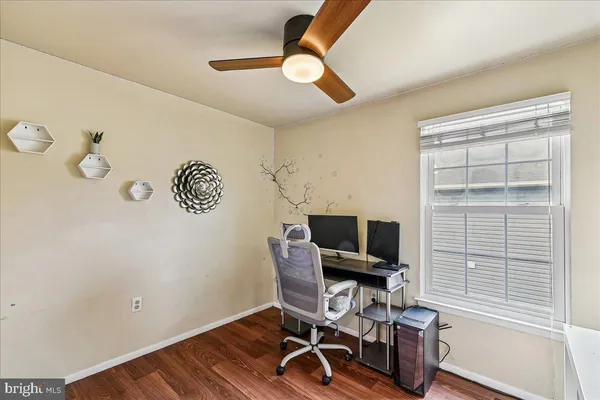 a view of a workspace with furniture and a window