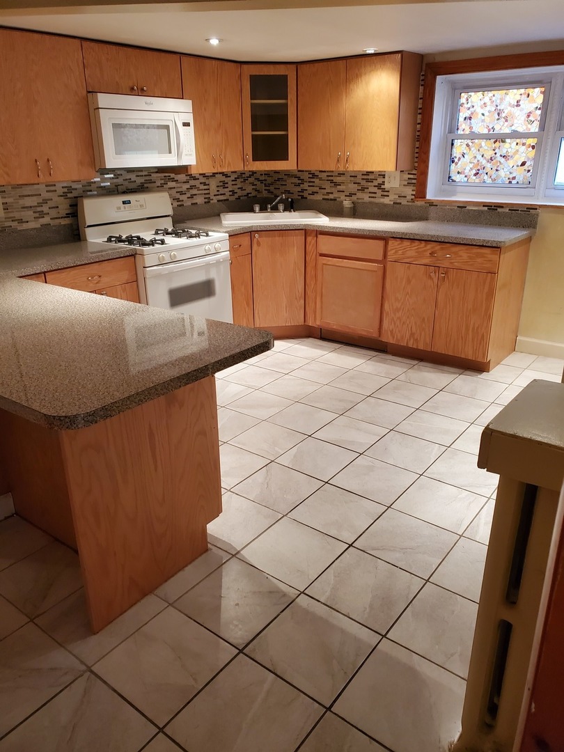 5135 West Roscoe Street, Unit B Chicago, IL 60641 - Photo 2 of 12 a kitchen with granite countertop a sink and a stove