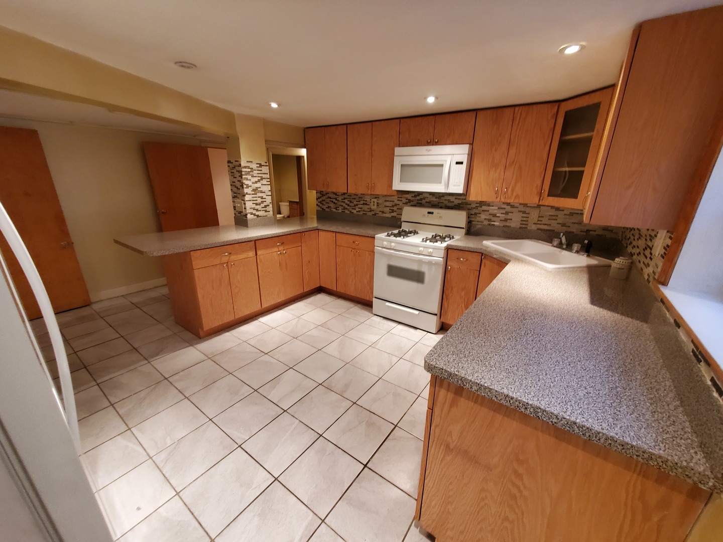 5135 West Roscoe Street, Unit B Chicago, IL 60641 - Photo 5 of 12 a kitchen with stainless steel appliances granite countertop a sink and cabinets
