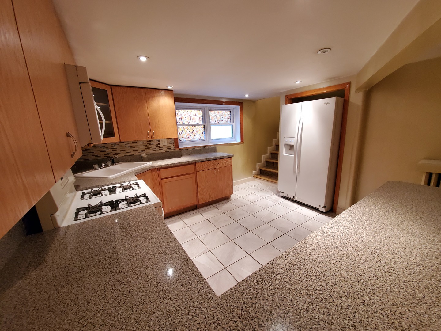 5135 West Roscoe Street, Unit B Chicago, IL 60641 - Photo 6 of 12 a kitchen with stainless steel appliances granite countertop a refrigerator and a stove