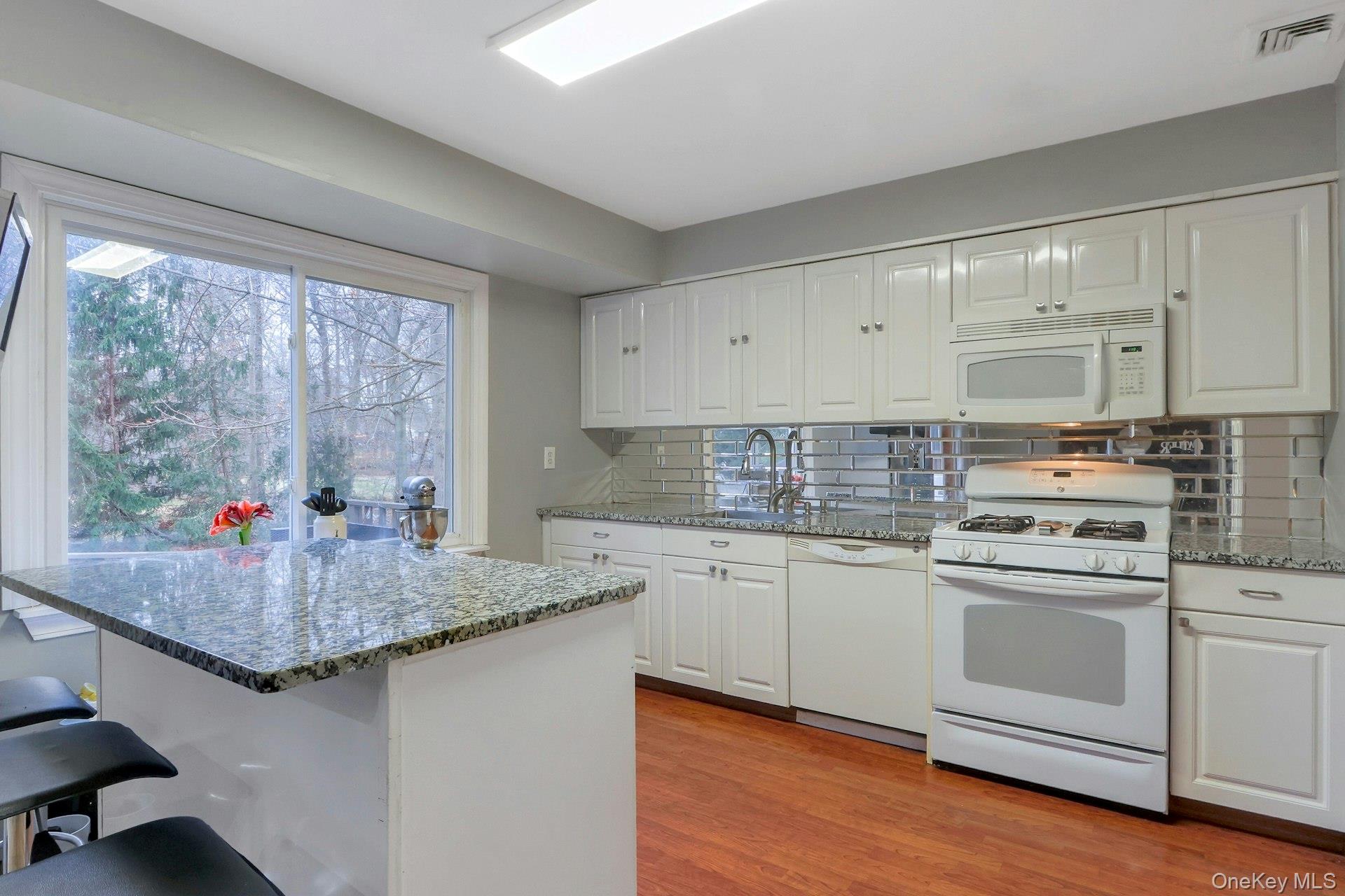 21 Mill Creek Road New City, NY 10956 - Photo 4 of 50 a kitchen with stainless steel appliances granite countertop a stove a sink and white cabinets with wooden floor