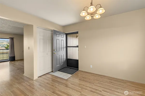 a view of an empty room with window and wooden floor