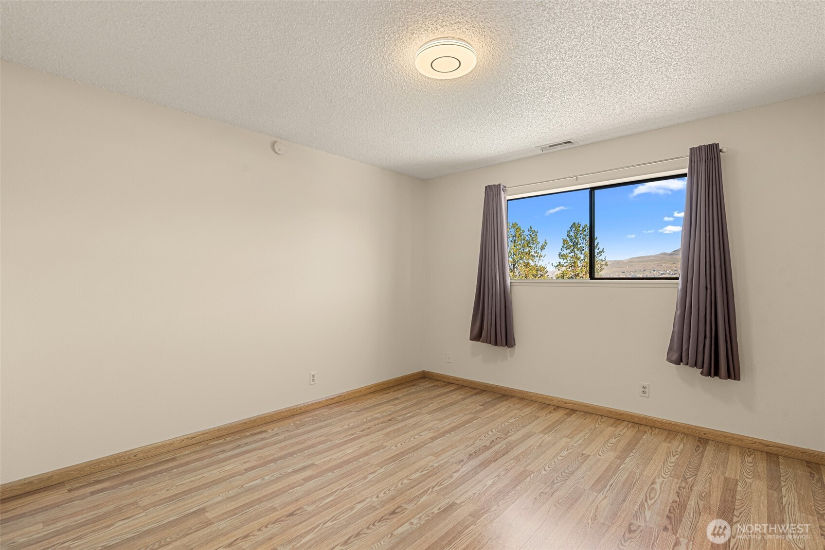407 Oregon Street, Unit 231 Wenatchee, WA 98801 - Photo 16 of 31 an empty room with wooden floor and door