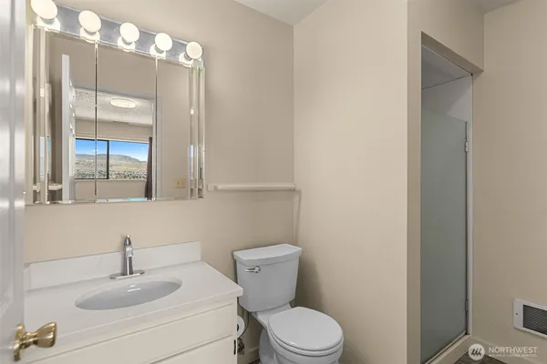 a bathroom with a toilet a sink and mirror