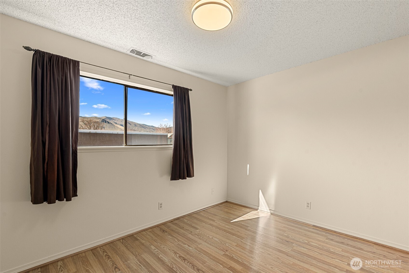 407 Oregon Street, Unit 231 Wenatchee, WA 98801 - Photo 19 of 31 a view of an empty room with wooden floor and a window