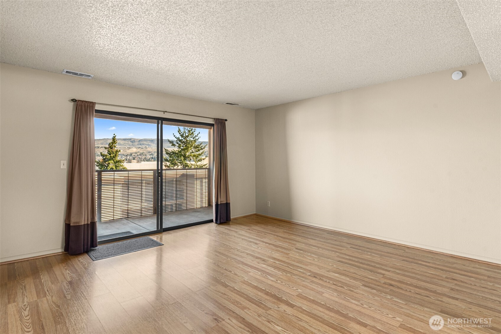 407 Oregon Street, Unit 231 Wenatchee, WA 98801 - Photo 7 of 31 an empty room with wooden floor and windows