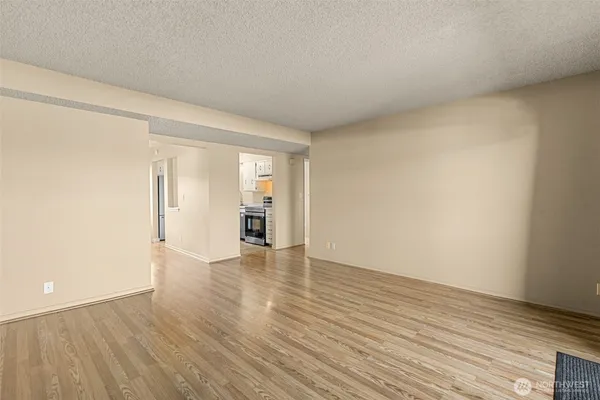 a view of an empty room and wooden floor and closet