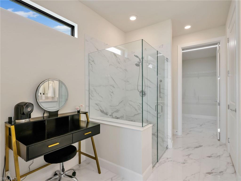 19724 Aqua View Lane Fort Myers, FL 33913 - Photo 20 of 44 a room with a table a mirror and a shower