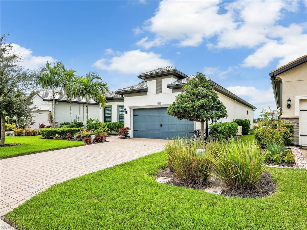 19724 Aqua View Lane Fort Myers, FL 33913 - Photo 3 of 44 a front view of a house with a yard and potted plants