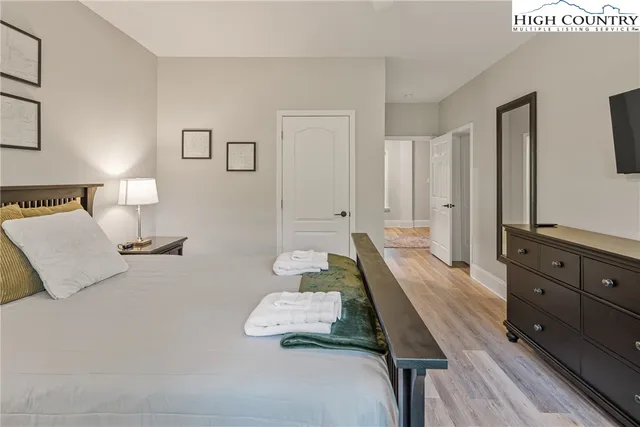 a spacious bedroom with a bed and a dresser