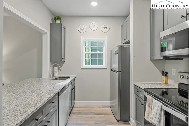a kitchen with stainless steel appliances granite countertop a refrigerator and a sink