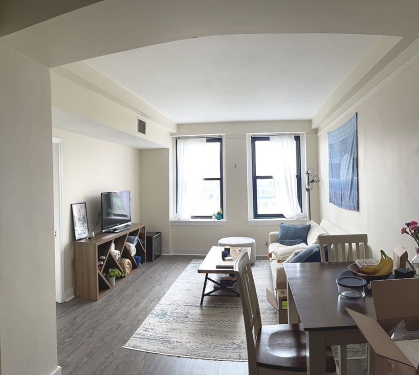 a living room with furniture a window and a flat screen tv