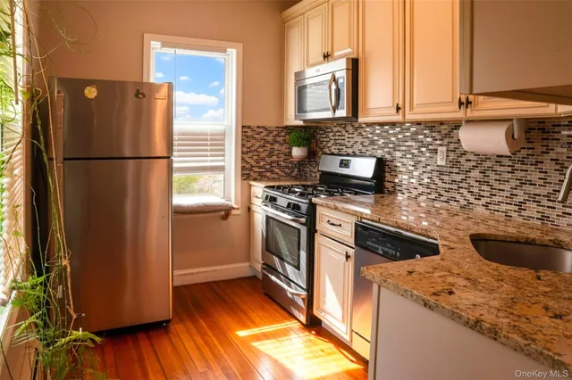 a kitchen with a refrigerator wooden floor and a sink
