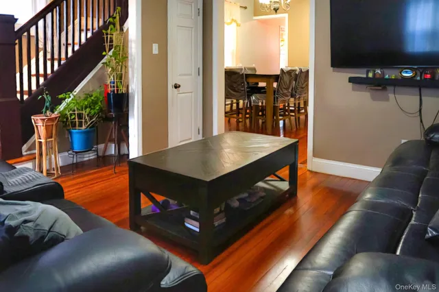 a living room with furniture a flat screen tv and a floor to ceiling window