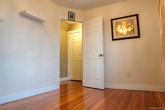 an empty room with wooden floor and closet
