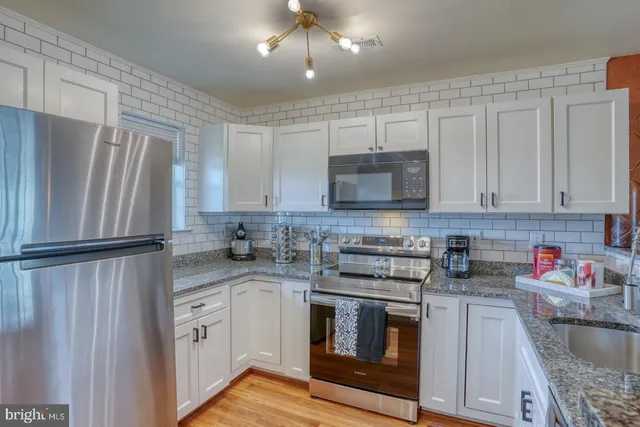 a kitchen with stainless steel appliances granite countertop a refrigerator sink and microwave