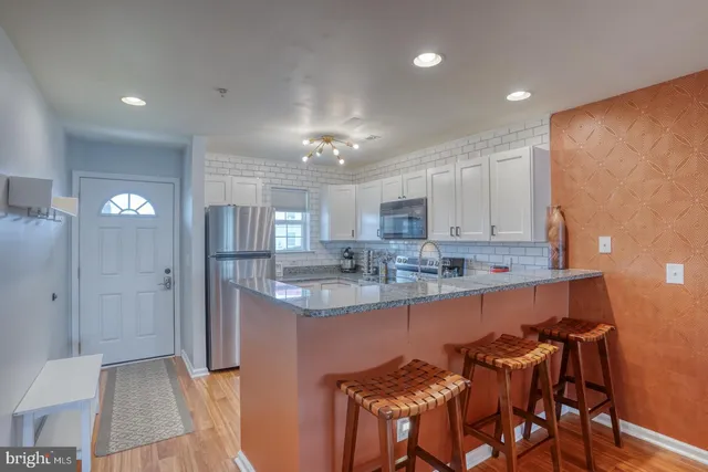 a kitchen with kitchen island granite countertop a sink and cabinets