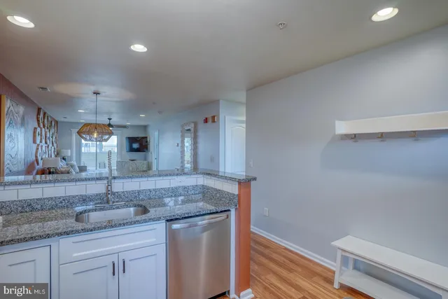 a bathroom with a granite countertop sink a toilet and mirror