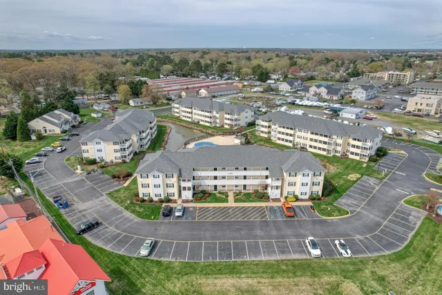 an aerial view of residential houses with outdoor space and parking