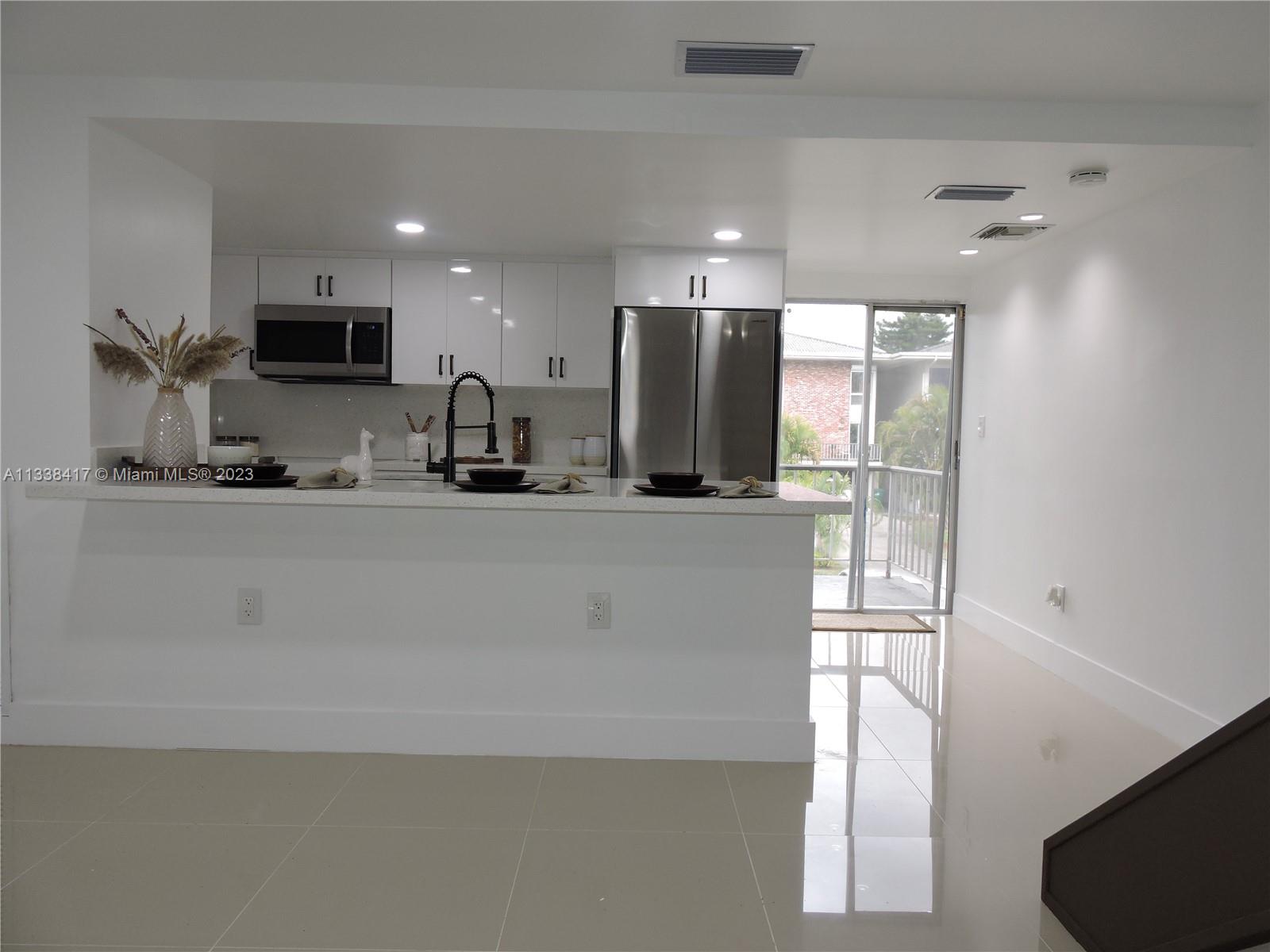 a kitchen with stainless steel appliances a refrigerator a sink a stove a microwave a counter top and oven