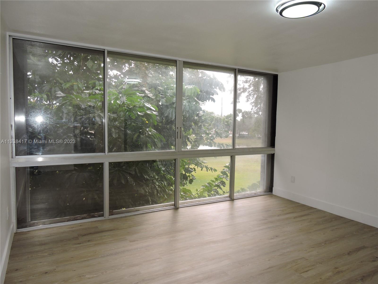 6762 Brookline Drive Hialeah, FL 33015 - Photo 12 of 25 a view of an empty room with wooden floor and a window