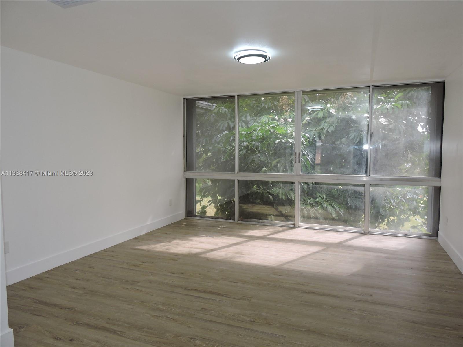 6762 Brookline Drive Hialeah, FL 33015 - Photo 15 of 25 a view of an empty room with wooden floor and a window