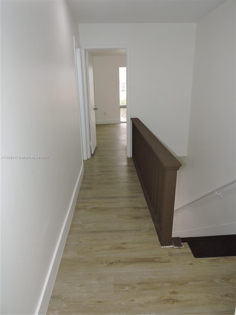 6762 Brookline Drive Hialeah, FL 33015 - Photo 22 of 25 a hallway with wooden floor and staircase