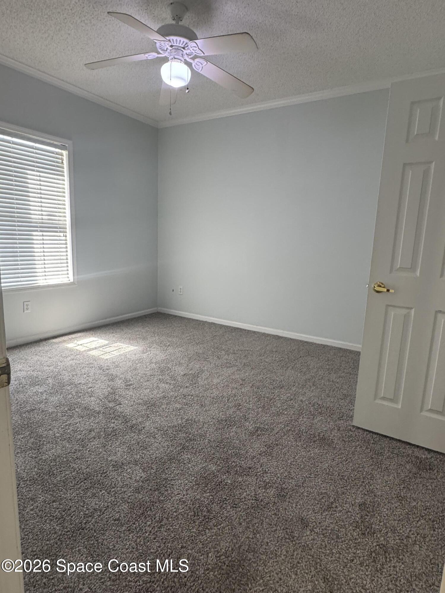 1130 Grapefruit Road Southeast Palm Bay, FL 32909 - Photo 11 of 14 an empty room with a ceiling fan and window