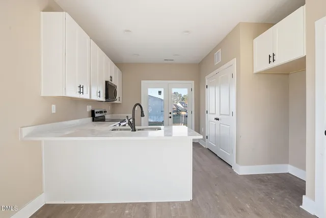 a view of kitchen with sink refrigerator and window