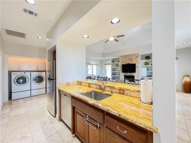 a kitchen with a sink and a stove top oven with wooden floor