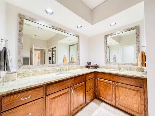 a spacious bathroom with a granite countertop sink double and mirror