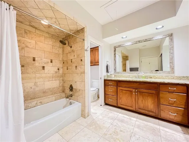 a spacious bathroom with a granite countertop tub sink shower and mirror