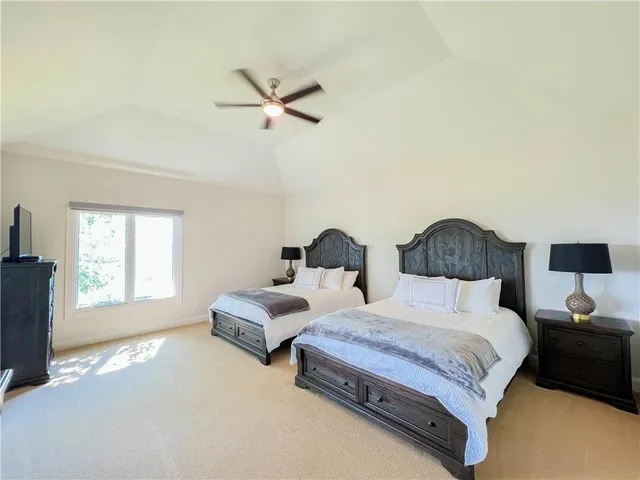 a spacious bedroom with two beds and a window