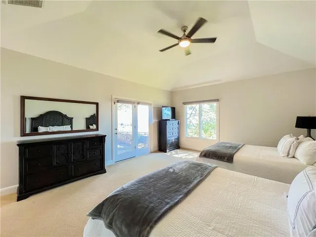 a bedroom with a bed and a dresser next to a window