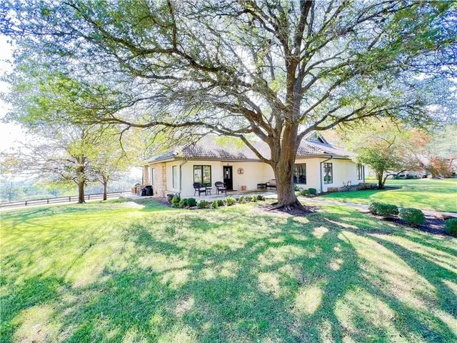 a front view of a house with yard and green space