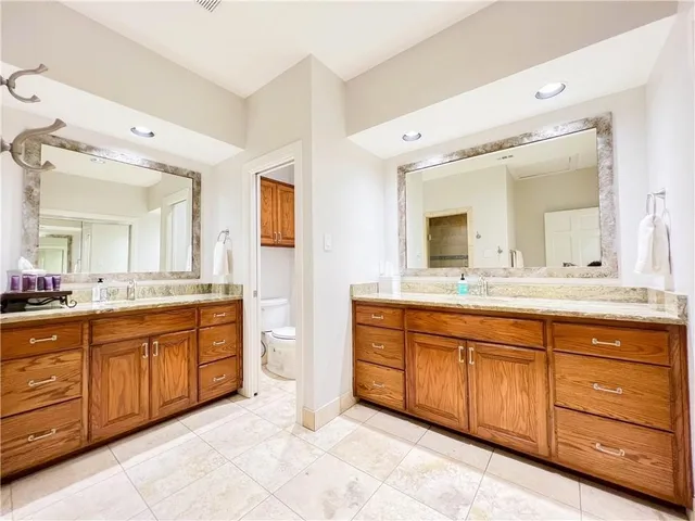 a spacious bathroom with a granite countertop double vanity sink and a mirror