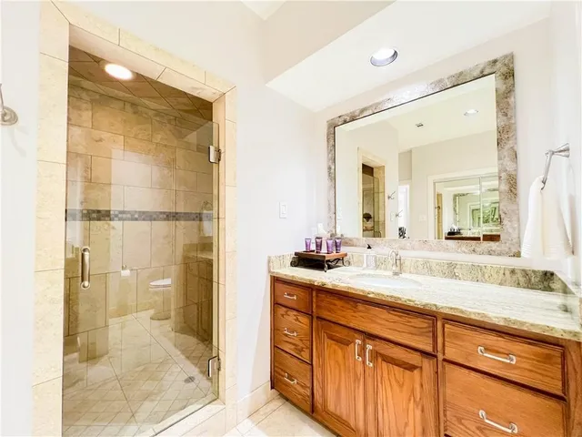a bathroom with a granite countertop sink mirror and shower
