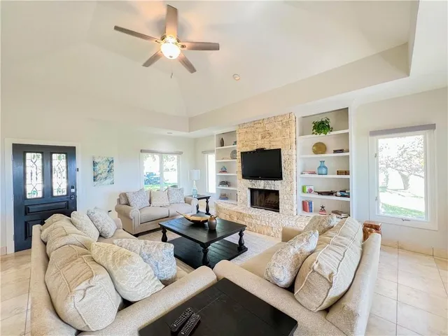 a living room with furniture a flat screen tv and a large window