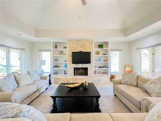 a living room with furniture a flat screen tv and a fireplace