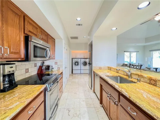 a large kitchen with granite countertop a sink and cabinets