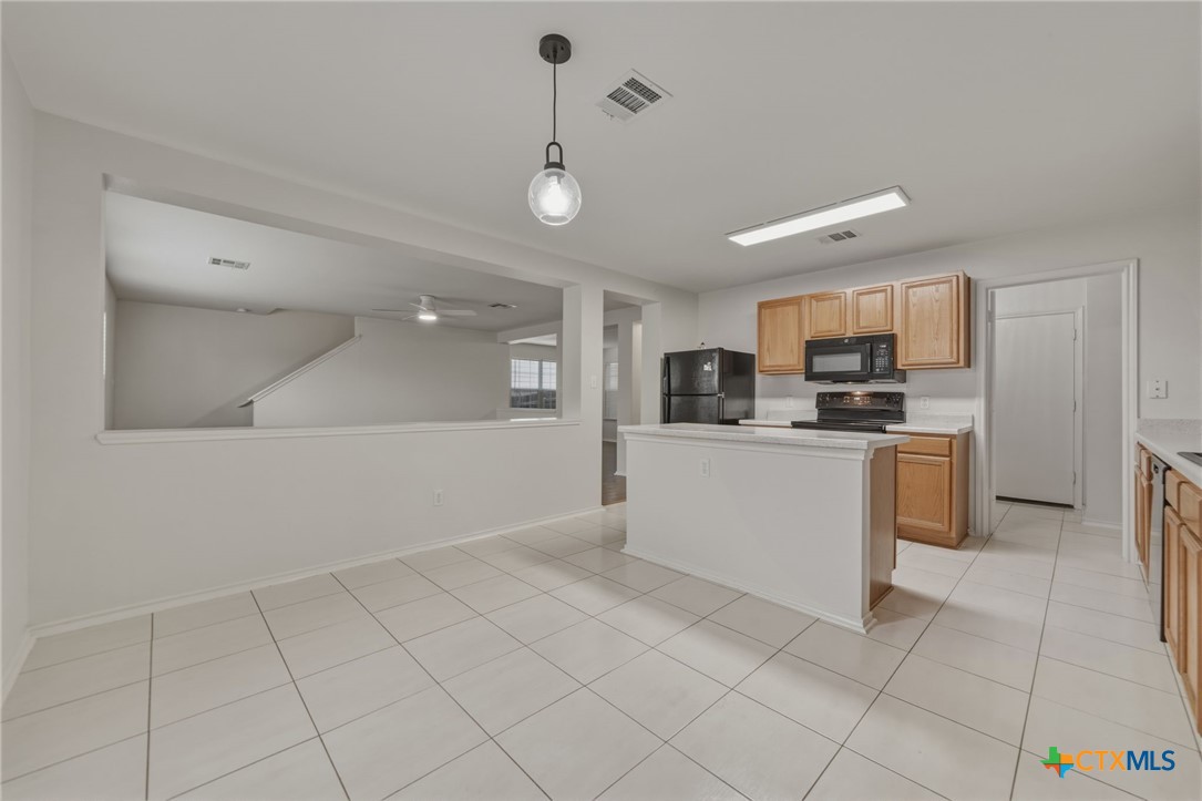 109 Comal Cove Elgin, TX 78621 - Photo 11 of 34 a kitchen with white cabinets a sink dishwasher and a stove with wooden floor