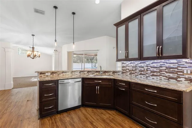 a kitchen with stainless steel appliances granite countertop hardwood floor sink and stove
