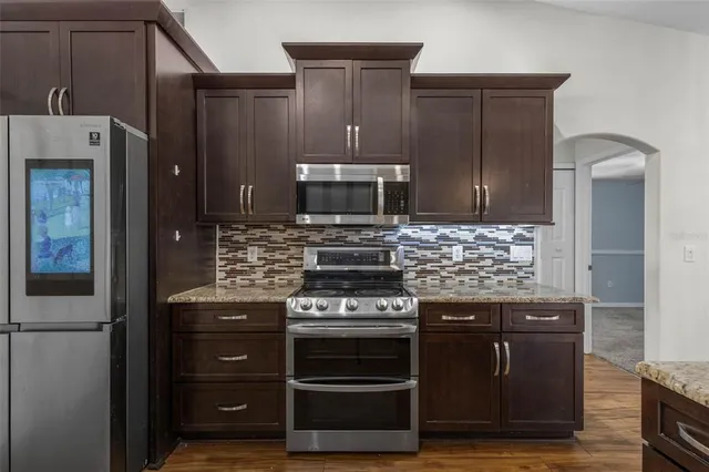 a kitchen with stainless steel appliances wooden cabinets and stove