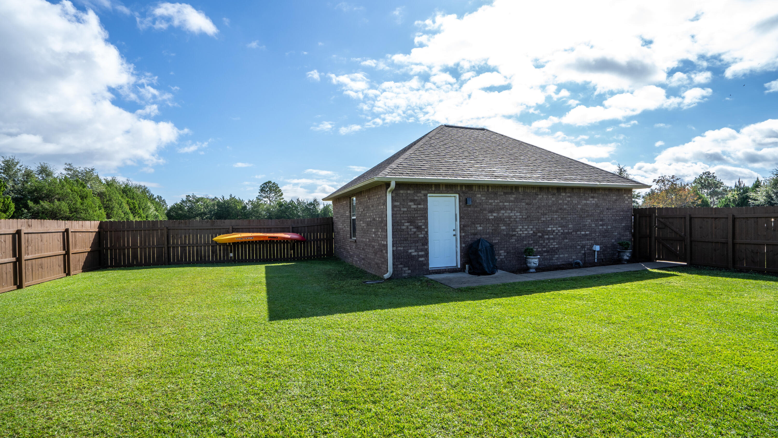 9606 South Trace Road Milton, FL 32583 - Photo 38 of 48 a backyard of a house with table and sofas