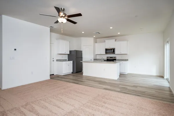 a view of kitchen with granite countertop cabinets and refrigerator