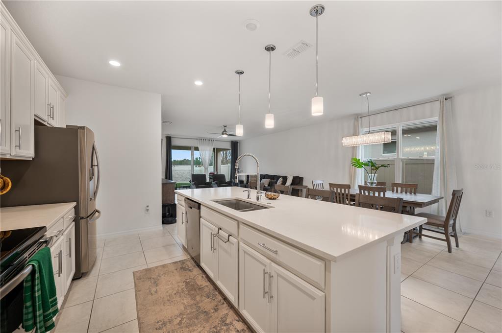 2887 Parkfield Road St. Cloud, FL 34772 - Photo 11 of 51 a kitchen with a sink a stove a refrigerator and chairs
