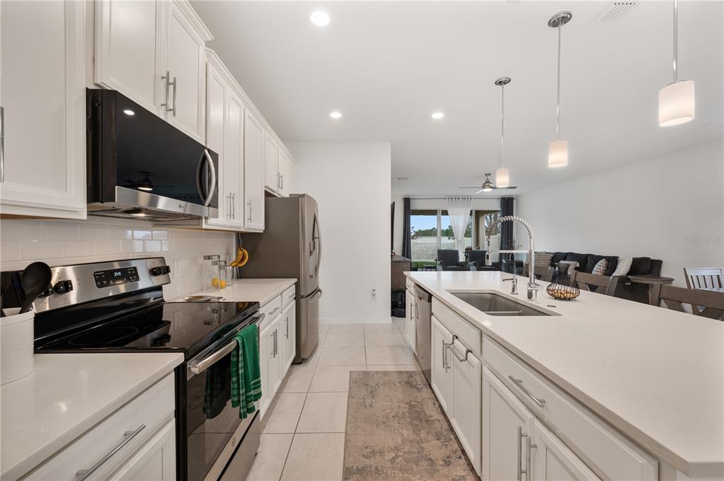2887 Parkfield Road St. Cloud, FL 34772 - Photo 12 of 51 a kitchen with a sink a stove and microwave